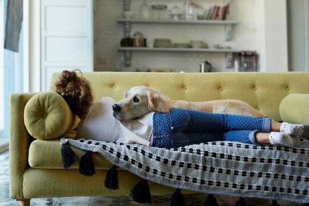 A girl and a dog lying on a couch